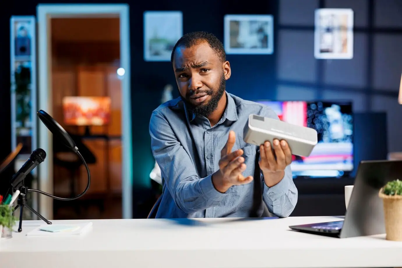 Mann stellt gesponserten tragbaren Lautsprecher vor.